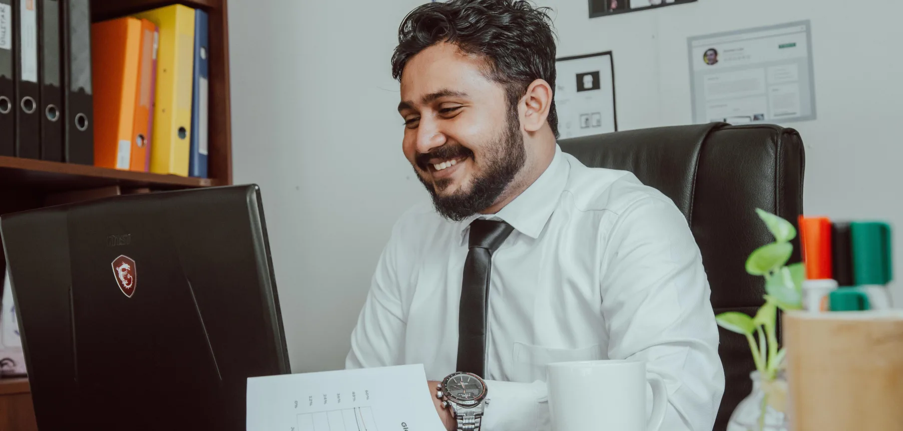 Offshore Filipino accountant reviewing financial reports at his desk